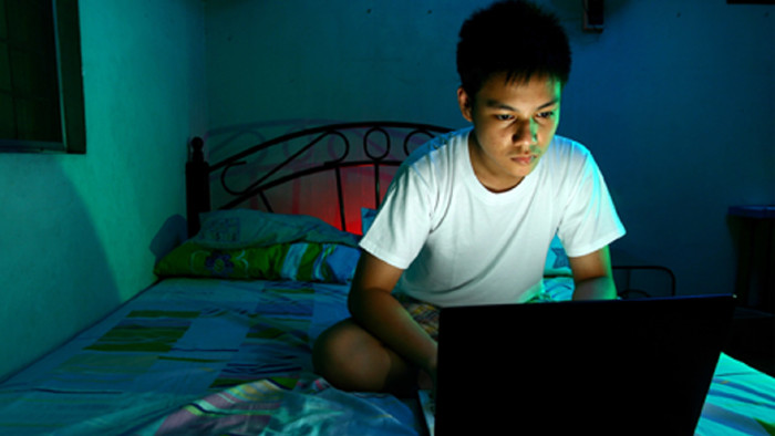 © Junpinzon, stock.adobe.com Jugendlicher mit Laptop auf dem Bett